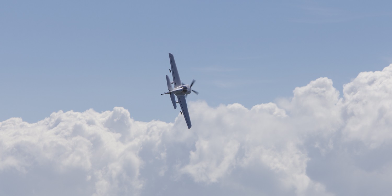 RA-2 performing aerobatic maneuver against clouds